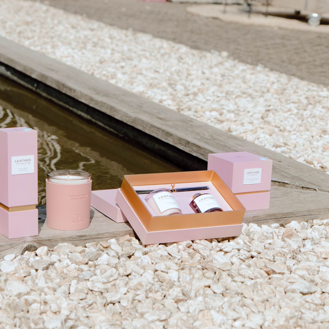 Elegant Pink Leather Porcelain Peony Gift Pack with candles by a serene water feature.