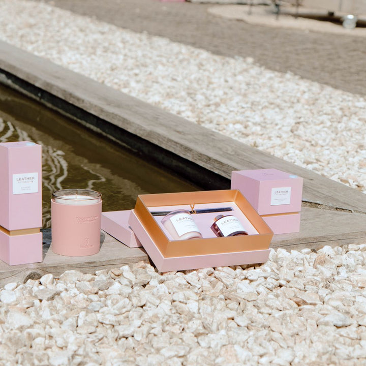 Elegant Pink Leather Porcelain Peony Gift Pack with candles by a serene water feature.