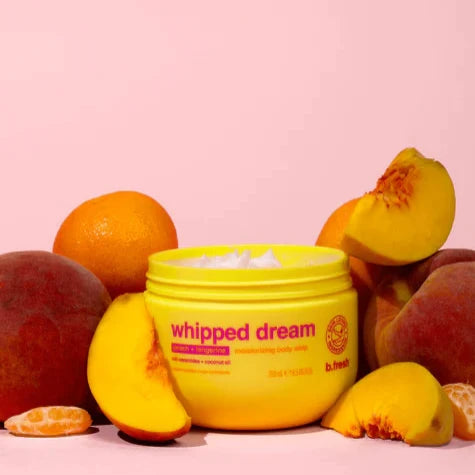 Whipped Dream Hydraterende Body Butter met perzik en mango, omringd door verse perziken.